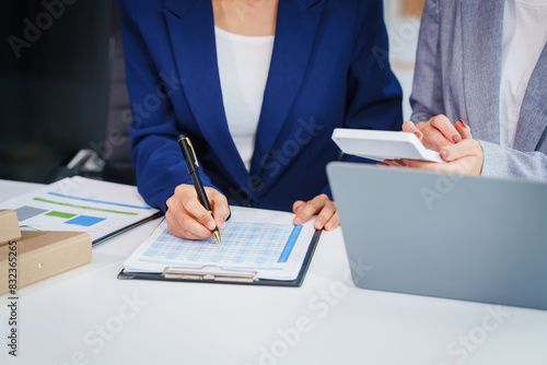 Fotografie Two Asian businesswomen collaborate on stock market strategies and financial services, exchanging comments and suggestions on loan applications and investment opportunities