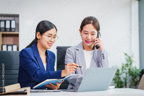 Two Asian businesswomen collaborate on stock market strategies and financial services, exchanging comments and suggestions on loan applications and investment opportunities.
