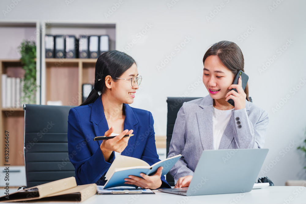 Two Asian businesswomen collaborate on stock market strategies and financial services, exchanging comments and suggestions on loan applications and investment opportunities. Two Asian businesswomen collaborate on stock market strategies and financial services, exchanging comments and suggestions on loan applications and investment opportunities.