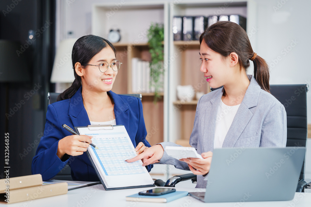 Two Asian businesswomen collaborate on stock market strategies and financial services, exchanging comments and suggestions on loan applications and investment opportunities. Two Asian businesswomen collaborate on stock market strategies and financial services, exchanging comments and suggestions on loan applications and investment opportunities.