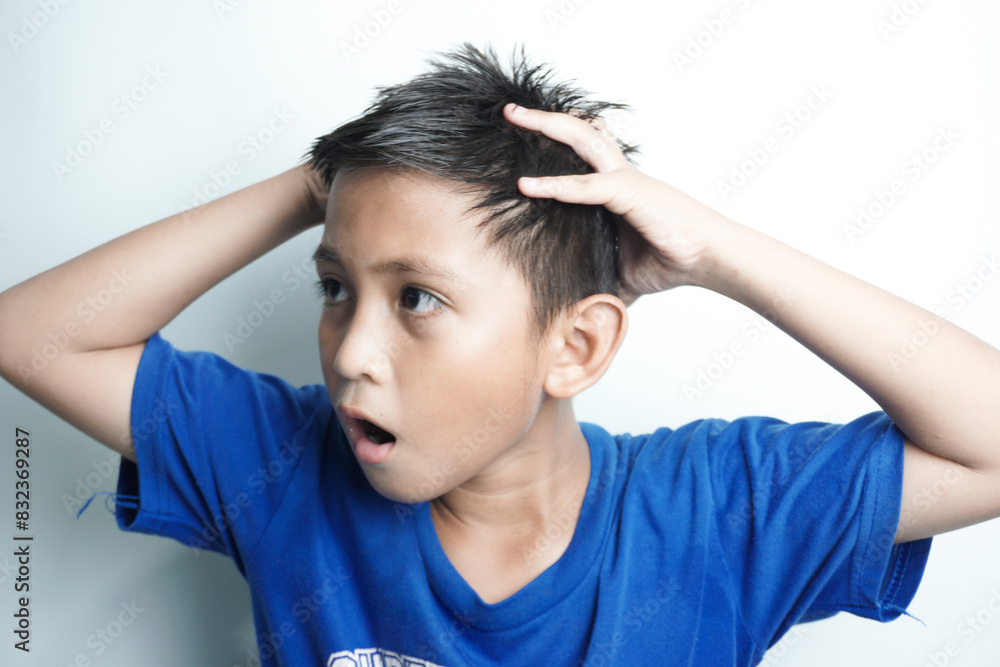 Portrait of little boy holding hands on head, screaming with opened mouth and crazy expression. Surprised or shocked face Portrait of little boy holding hands on head, screaming with opened mouth and crazy expression. Surprised or shocked face
