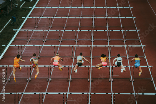 Female track and Field athletes at 100 m hurdles. Dynamic sport photo. Sprint race before world championship and summer game in Paris 2024. Professional Athletics Event.