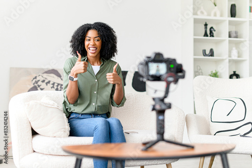 Full of energy and charisma, an African-American vlogger records a lively session for her followers, her expressive thumbs up signaling success and approval