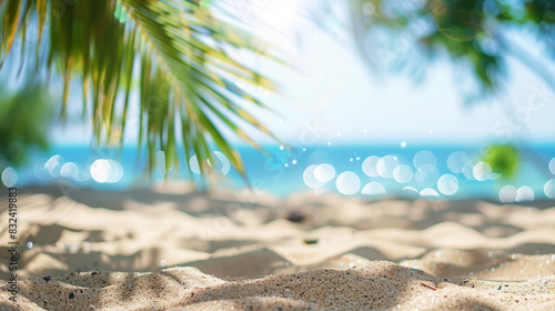 Defocused tropical beach view through palm leaves with sparkling ocean and bright bokeh effect