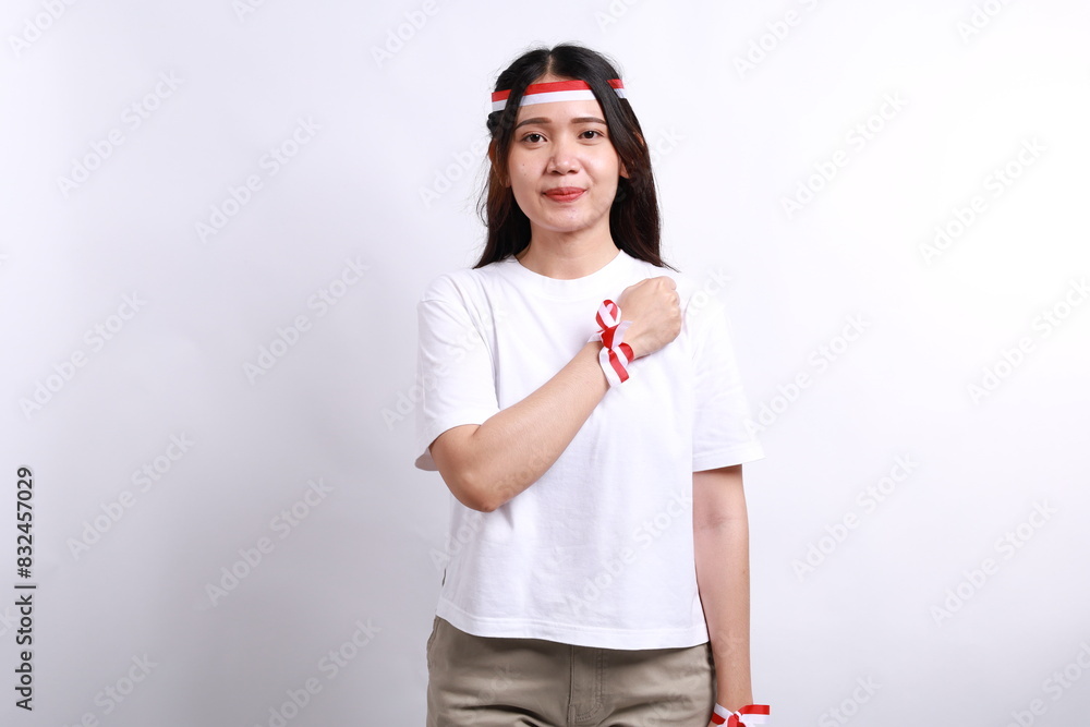 Young Indonesian girl celebrate indonesia independence day with hand on the chest Young Indonesian girl celebrate indonesia independence day with hand on the chest