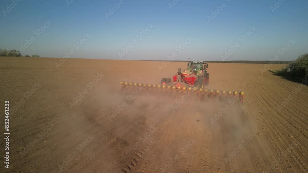 Green tractor works on the field sowing sunflower. Tractor planting corn in Ukraine Green tractor works on the field sowing sunflower. Tractor planting corn in Ukraine