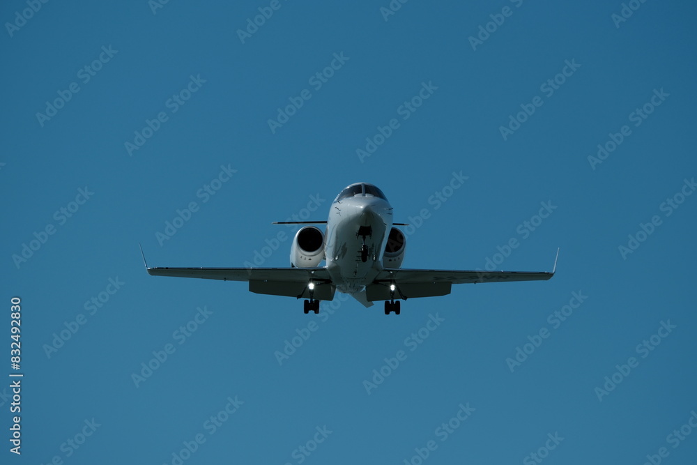 Obraz premium Airplane in the blue sky near the airport. The plane is preparing to land