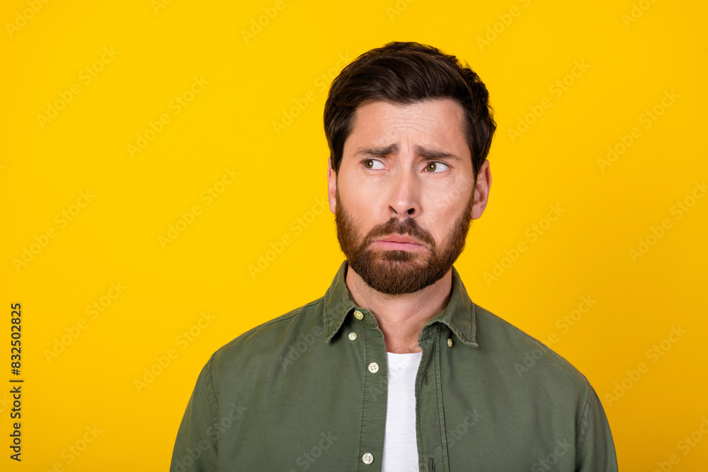 Photo of nice young man look empty space wear khaki shirt isolated on yellow color background