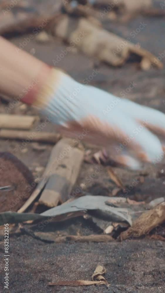Close-up of hands of eco-volunteer collecting garbage from ground in order to save eco-system from destruction and avoid appearance of microplastics or trash interfering with tourists' recreation. Close-up of hands of eco-volunteer collecting garbage from ground in order to save eco-system from destruction and avoid appearance of microplastics or trash interfering with tourists' recreation.