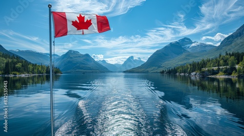 Canadian flag flying from a boat on a scenic lake, surrounding mountains. Canada Day, Civic Holiday photo