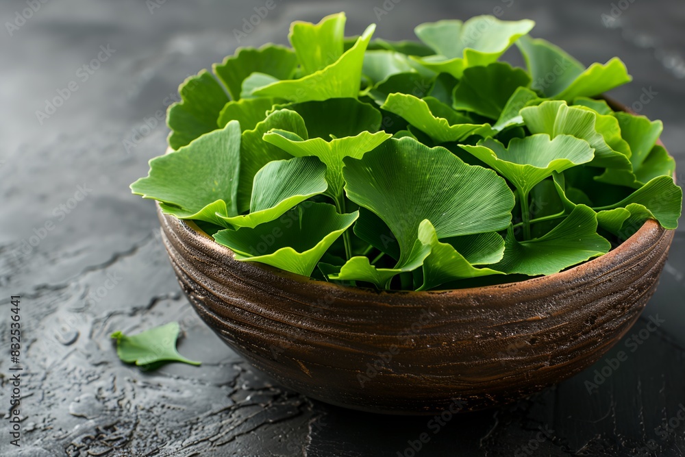 wooden bowl filled with ginkgo biloba leaves on a table top wooden bowl filled with ginkgo biloba leaves on a table top