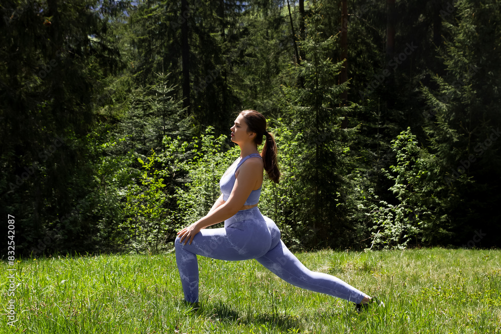 woman doing physical exercises, sports, yoga, in a blue tight-fitting suit in the fresh air woman doing physical exercises, sports, yoga, in a blue tight-fitting suit in the fresh air