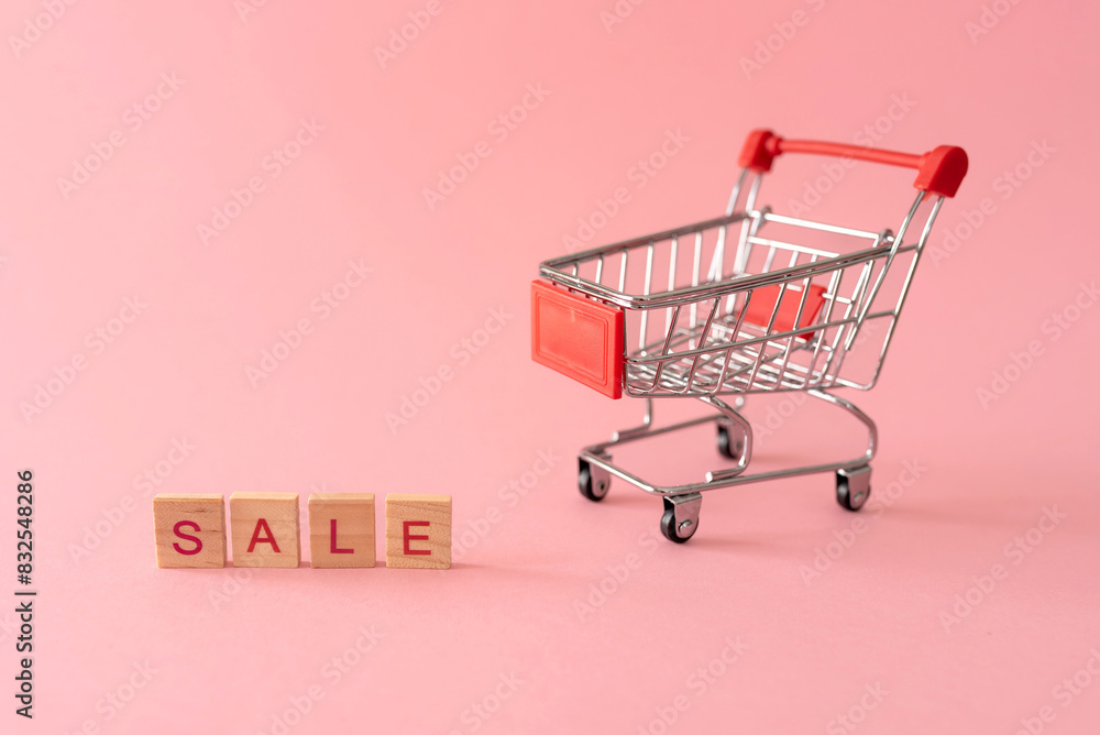Small shopping cart with word sale on pink background Small shopping cart with word sale on pink background