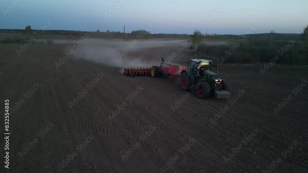 Green tractor works on the field sowing sunflower. Tractor planting corn in Ukraine Green tractor works on the field sowing sunflower. Tractor planting corn in Ukraine