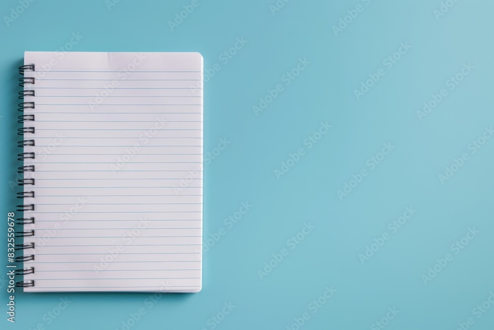 A spiral notebook is open to a blank page A spiral notebook is open to a blank page