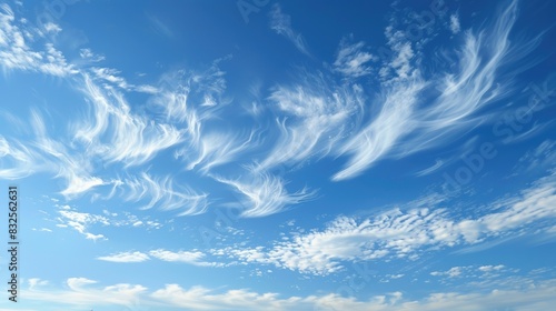 A serene sky with soft, wispy clouds, gently touched by the warm light of the late afternoon sun photo