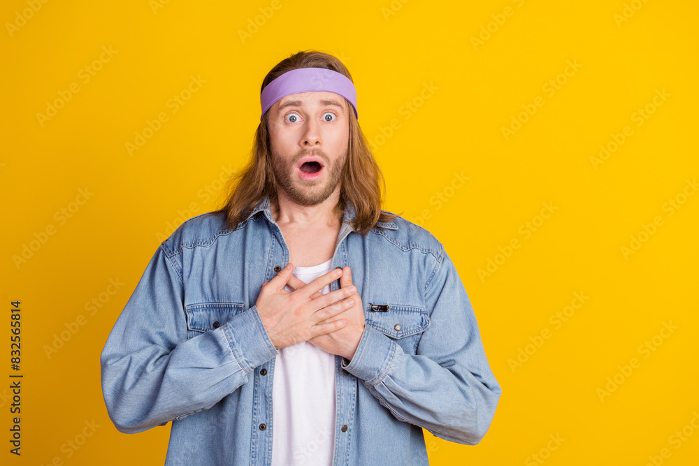 Photo portrait of attractive young hippie man touch chest frightened wear trendy denim outfit isolated on yellow color background Photo portrait of attractive young hippie man touch chest frightened wear trendy denim outfit isolated on yellow color background