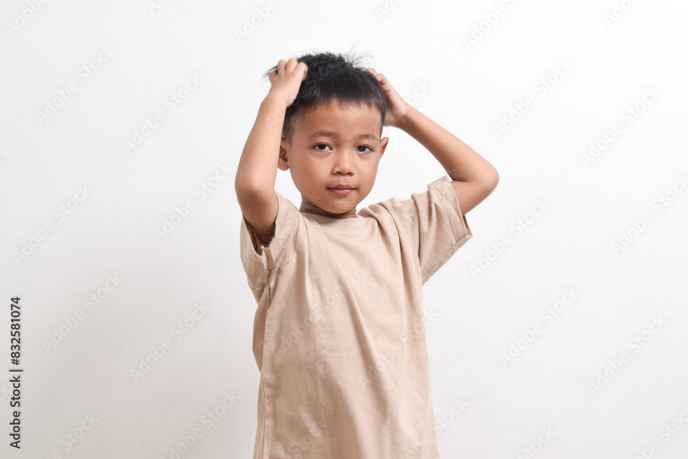 Image of Asian child pose holding head, headache concept on white background. portrait of an Asian boy Image of Asian child pose holding head, headache concept on white background. portrait of an Asian boy