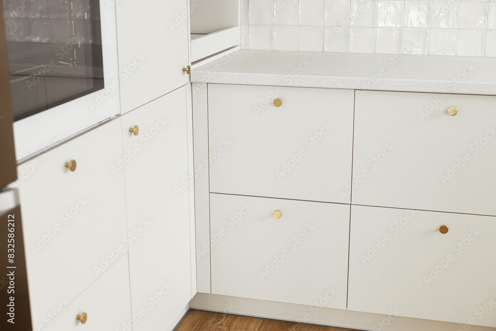 Modern kitchen interior. Stylish white kitchen cabinets with brass knobs and electric oven close up in new scandinavian house. Modern minimal kitchen design Modern kitchen interior. Stylish white kitchen cabinets with brass knobs and electric oven close up in new scandinavian house. Modern minimal kitchen design