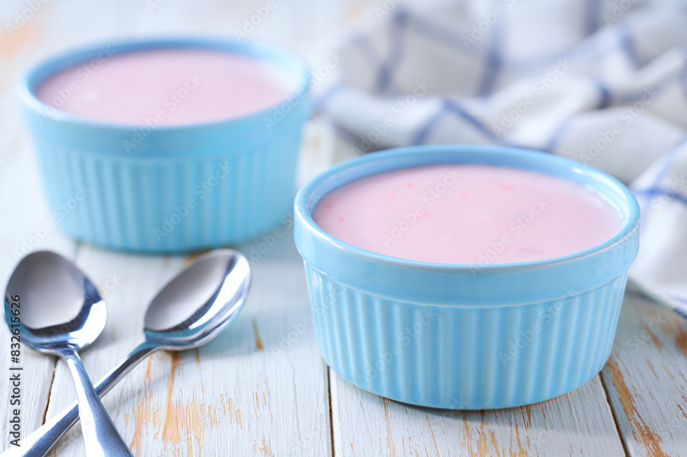 pink fruit yogurt in a ceramic bowl with spoon on a light background, selective focus. pink fruit yogurt in a ceramic bowl with spoon on a light background, selective focus.