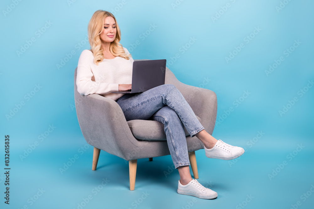 Photo of lovely charming woman wear stylish white clothes sit hold netbook device isolated on blue color background Photo of lovely charming woman wear stylish white clothes sit hold netbook device isolated on blue color background