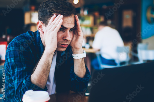 Good looking intelligent student dressed in casual clothing deeply thinking while preparing for upcoming examinations in cafe.Smart professional developer feeling tired during remote work indoors photo