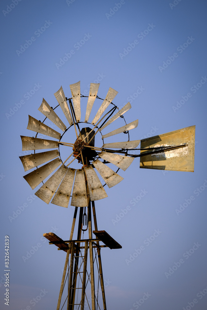 A pumping windmill in Namibia, used to draw water from a well, stands against a clear blue sky. A pumping windmill in Namibia, used to draw water from a well, stands against a clear blue sky.