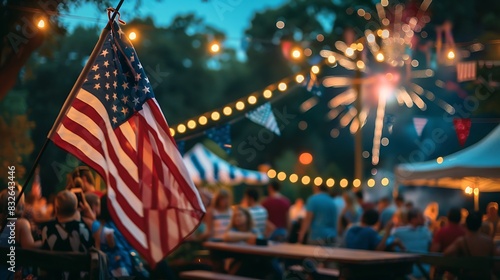 The photo shows a 4th of July celebration with fireworks in the background and an American flag in the foreground.
