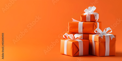 Collection of Orange Gift Boxes Tied with Golden Bows, Arranged on Orange Background