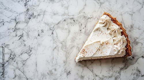  A pie sits atop a white marble counter, one slice featuring an unsweetened portion, the other boasting frosted whites atop the remaining pie photo