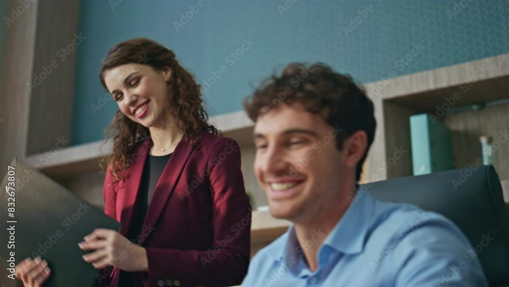 Smiling boss giving documents after signing to woman secretary in office closeup Smiling boss giving documents after signing to woman secretary in office closeup