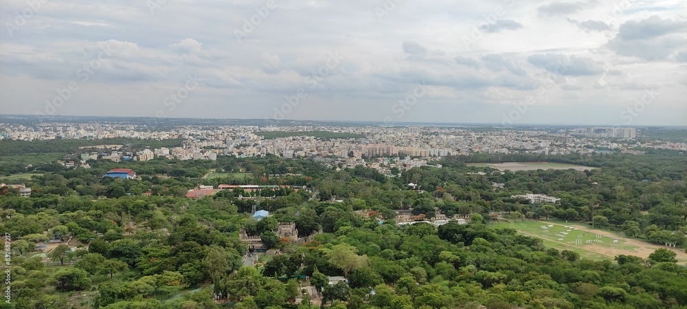 Aerial view of a sprawling city with a mix of green and urban landscapes.