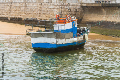 Cascais beach near Lisbon in Portugal. Cloudy day, empty beach, some fishermen's boats