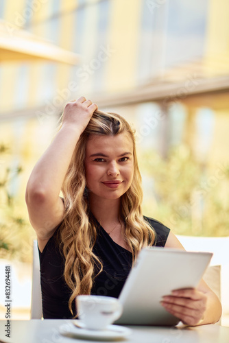 Elegant Businesswoman Enjoying a Productive Break at a Cafe with Her Tablet.