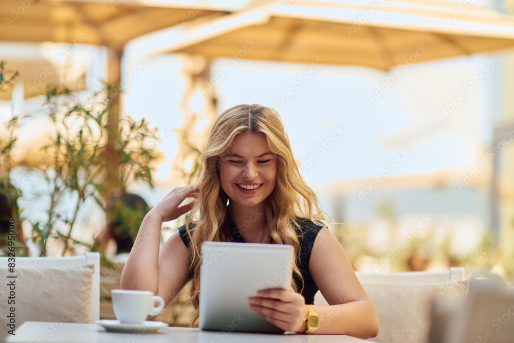 Elegant Businesswoman Enjoying a Productive Break at a Cafe with Her Tablet. Elegant Businesswoman Enjoying a Productive Break at a Cafe with Her Tablet.