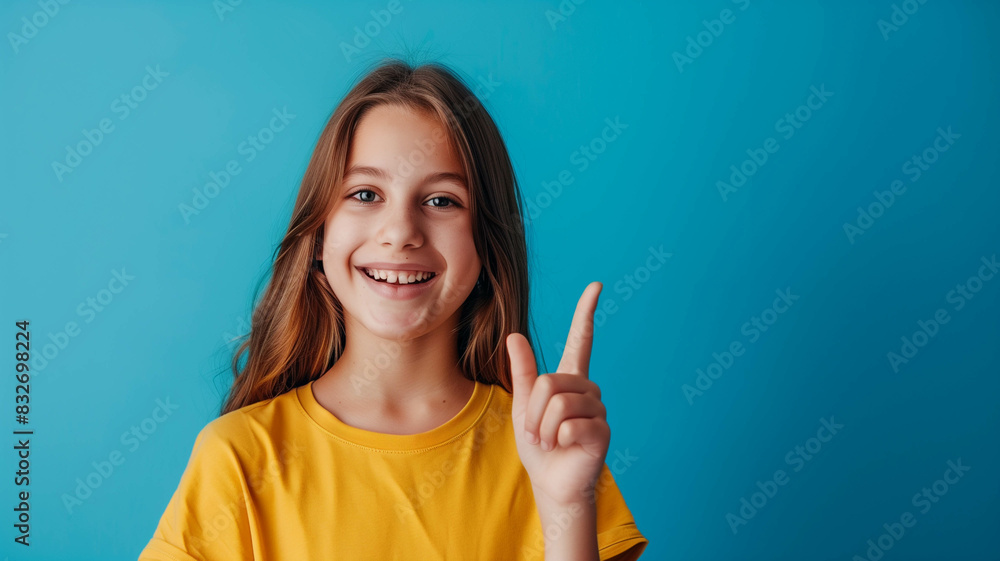 Cheerful girl in yellow, presenting an empty space in her hand with a blue color background Cheerful girl in yellow, presenting an empty space in her hand with a blue color background
