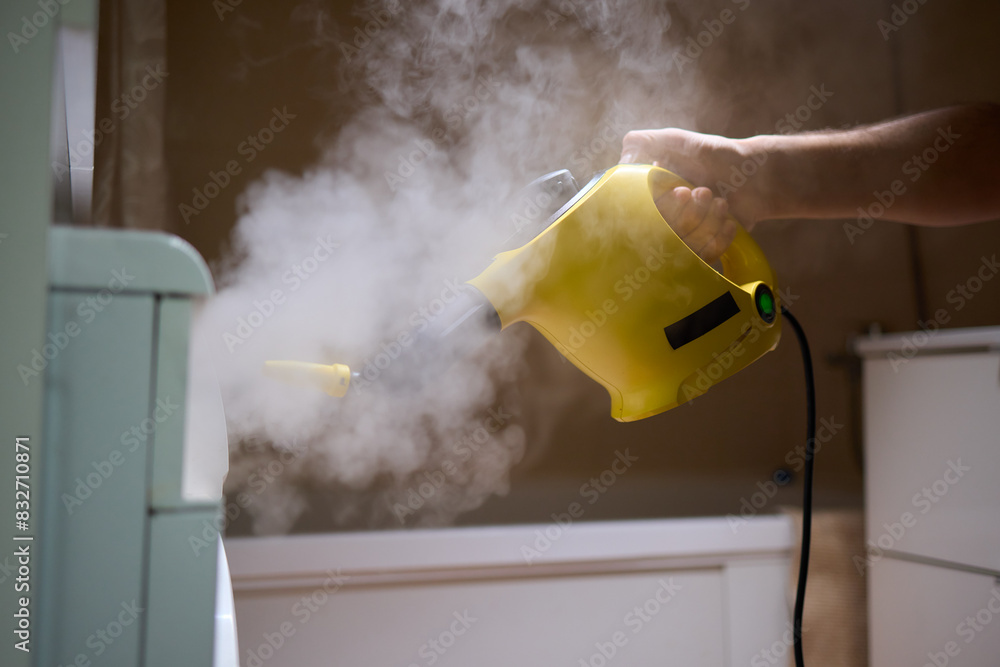 Obraz na plátně hand in gloves. Using a steam cleaner to clean a washing machine