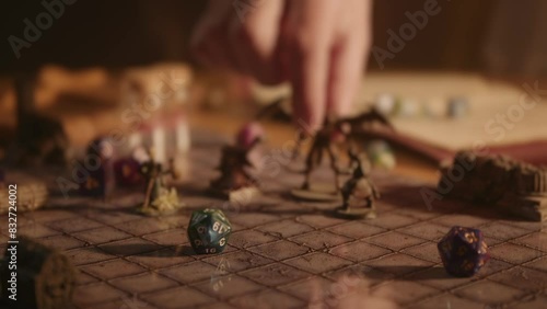 A person playing a tabletop roleplaying game with dice and miniatures photo