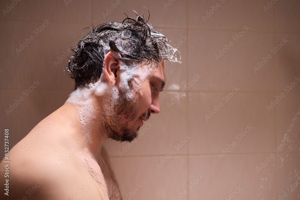 Man washing hair with shampoo in shower, creating foamy lather - personal hygiene care. Man washing hair with shampoo in shower, creating foamy lather - personal hygiene care.