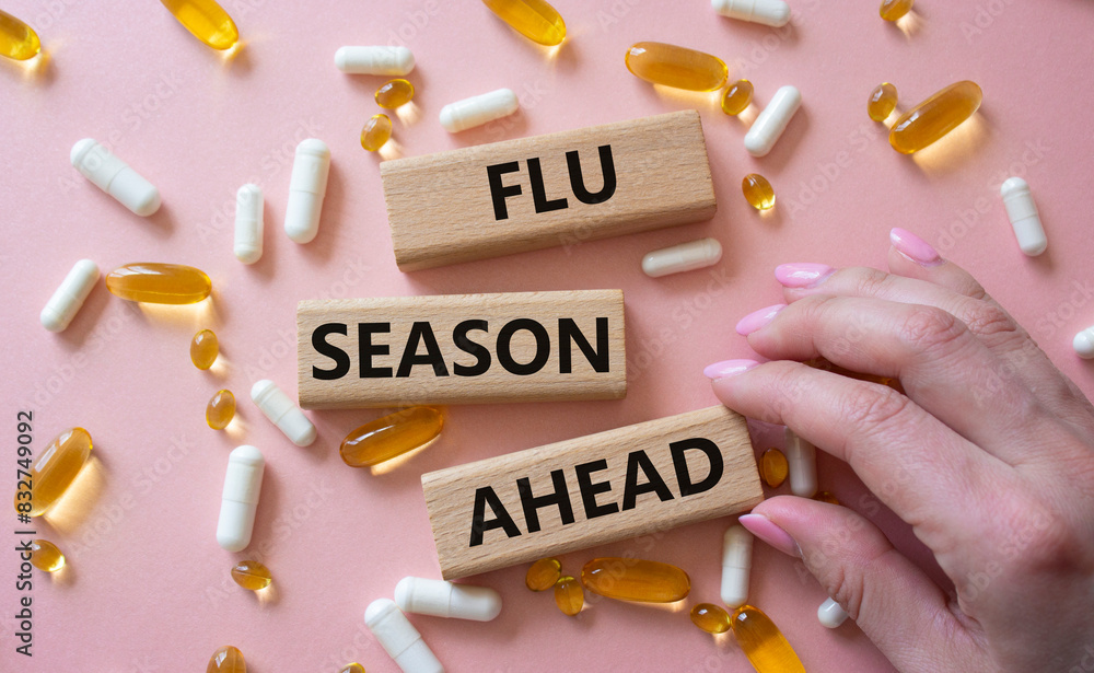 Flu Season Ahead symbol. Concept word Flu Season Ahead on wooden blocks. Doctor hand. Beautiful pink background with pills. Medicine and Flu Season Ahead concept. Copy space