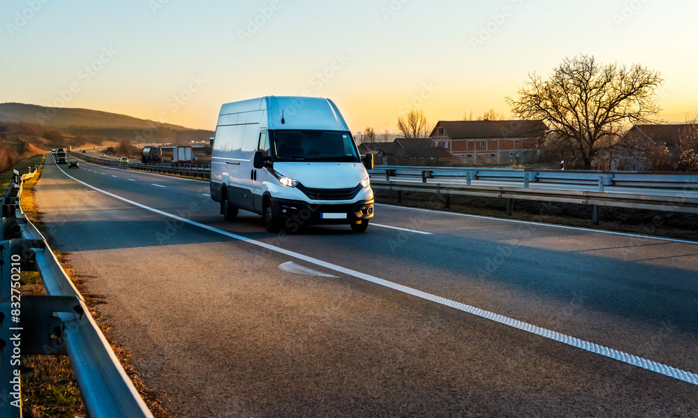 White cargo van at the open highway at sunset White cargo van at the open highway at sunset
