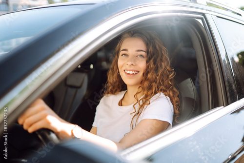 Relaxed woman enjoys drive while sitting in a car. Car travel concept. Lifestyle.