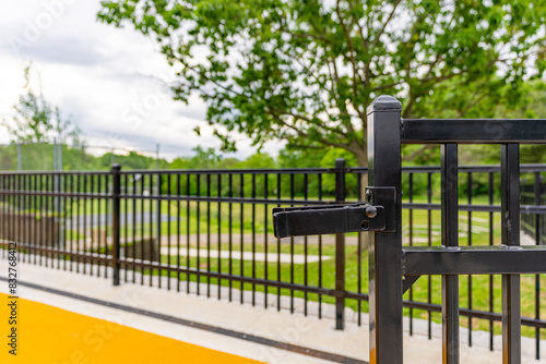 Φωτογραφία Close-up photo of an ornamental black metal fence gate latch at a colorful playground
