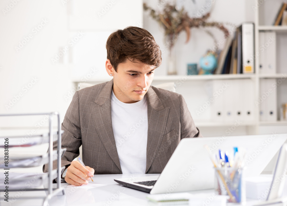 Obraz premium Man office manager sitting at table and using laptop computer