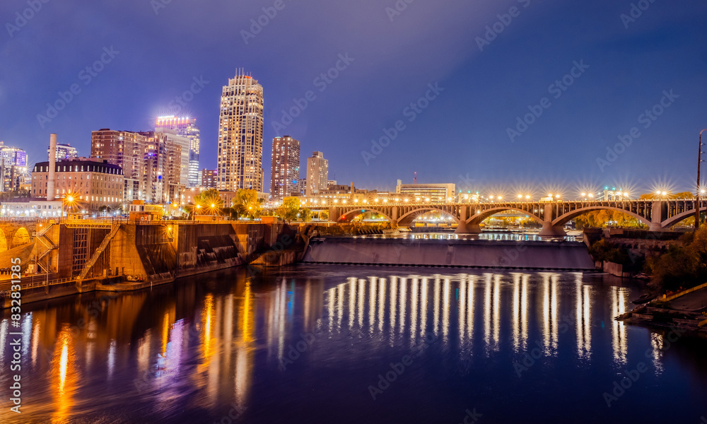Twilight cityscape with illuminated bridge reflections