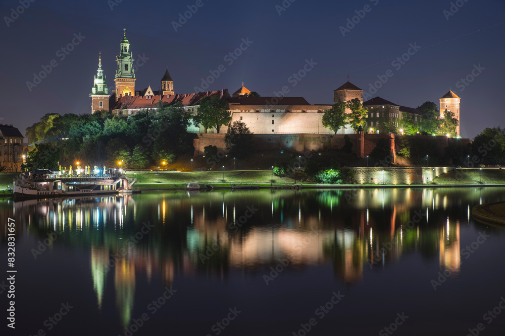 Illuminated wawel castle at night by vistula river
