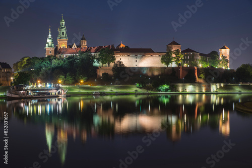 Illuminated wawel castle at night by vistula river