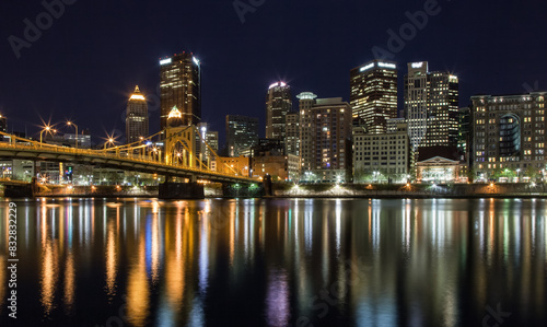 City skyline at night with illuminated bridge reflections