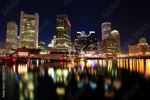 City skyline at night with illuminated buildings and reflections