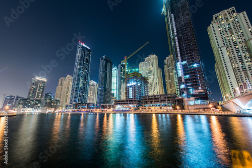 Dazzling urban skyline at night by waterfront